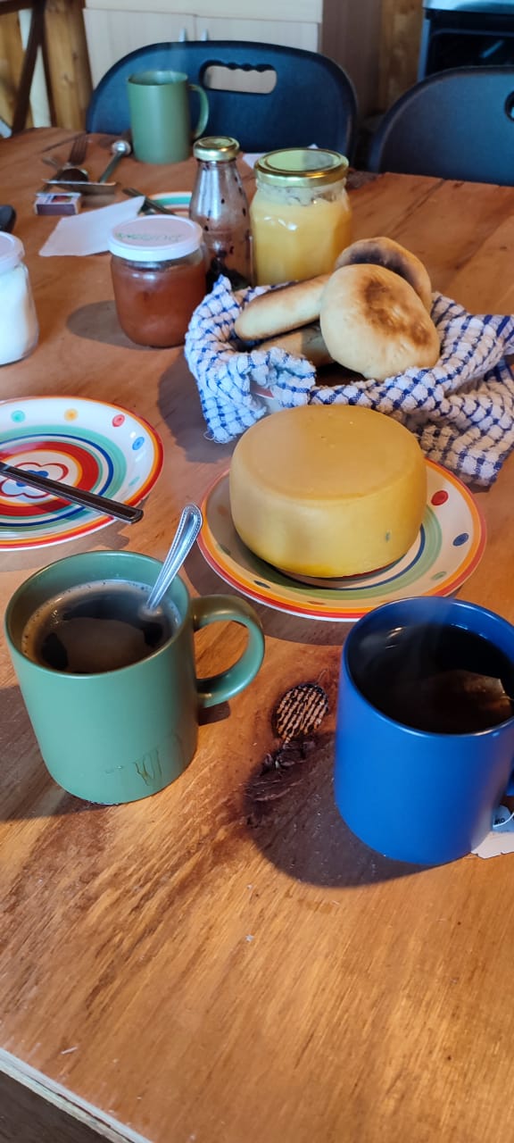 Imagen de un desayuno tradicional chileno con pan amasado, queso de campo y mermelada casera